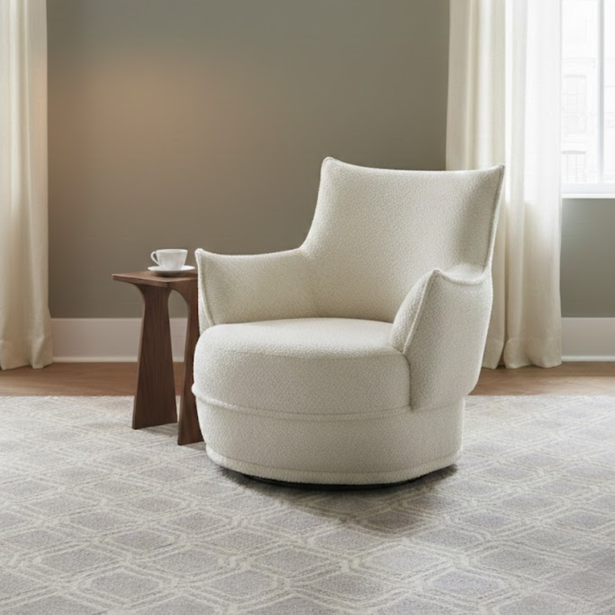 White armchair in a room with a small table and window curtains.