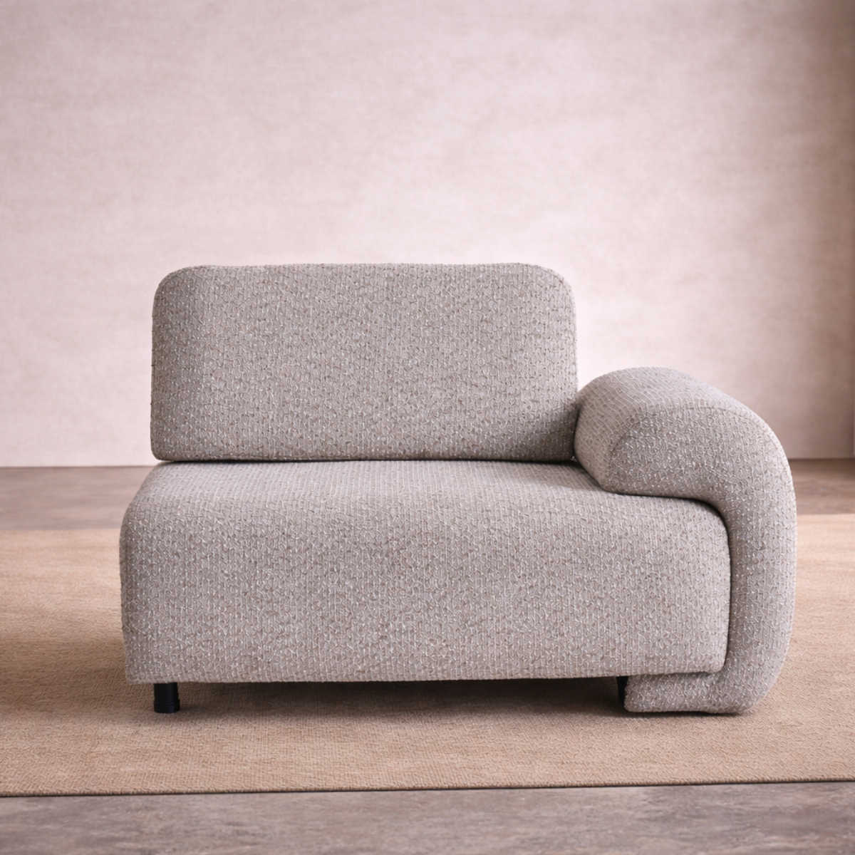 Gray armchair on a wooden floor with a neutral wall background